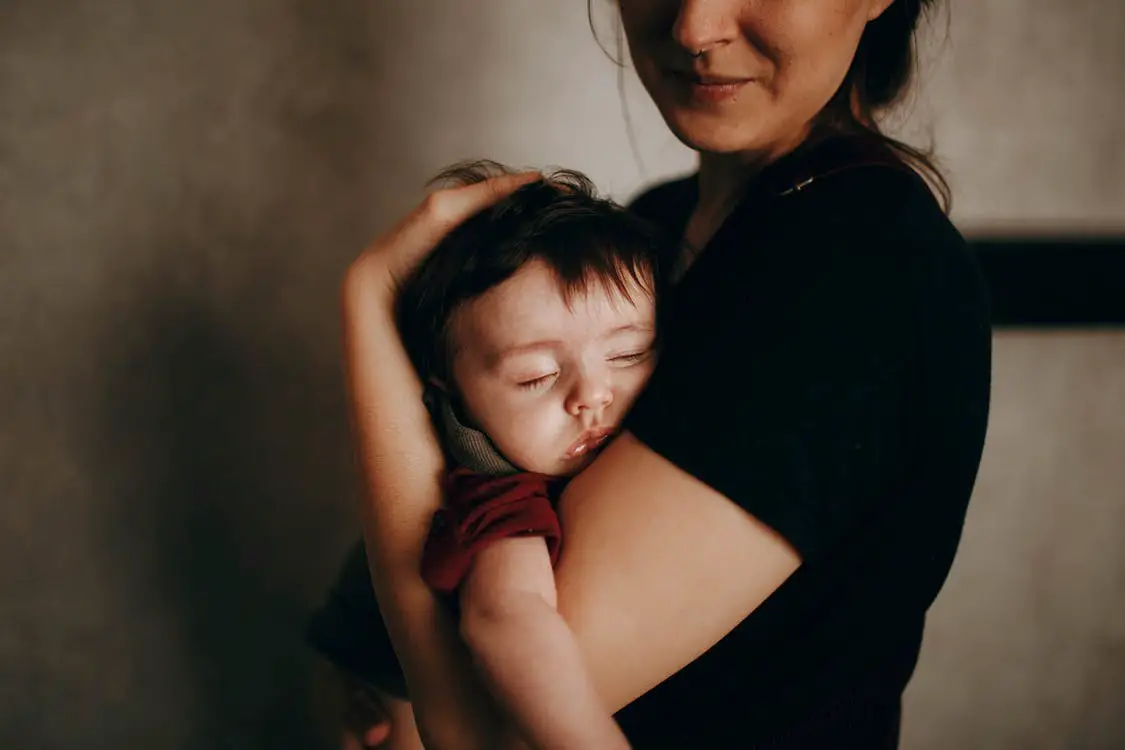 Baby asleep in mother’s arms